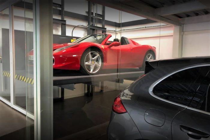 Imagen del interior de un taller donde se ve un coche elevándose por un montacargas