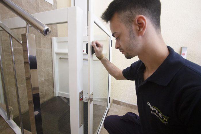 Técnico de mantenimiento realizando tareas de mantenimiento en un ascensor duplex