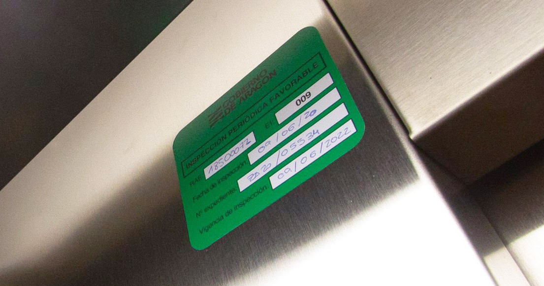 Adhesivo de color verde en un ascensor con una inspección técnica favorable del OCA