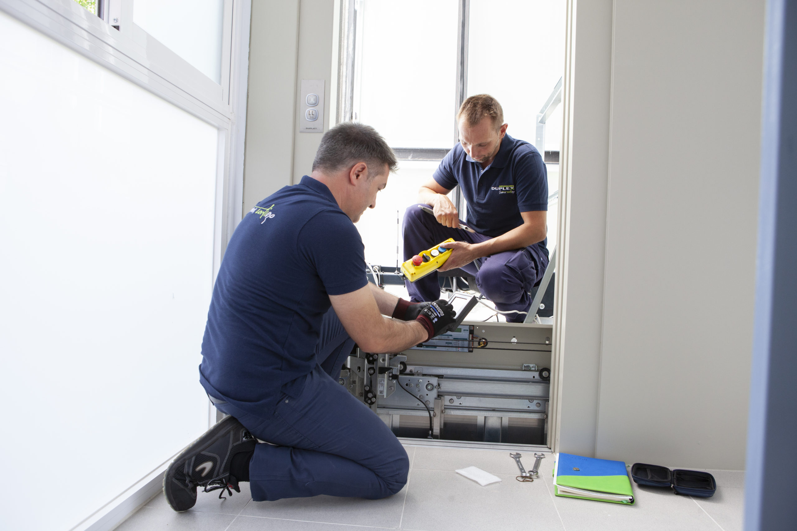 Dos técnicos de Duplex Ascensores revisando el funcionamiento de una instalación