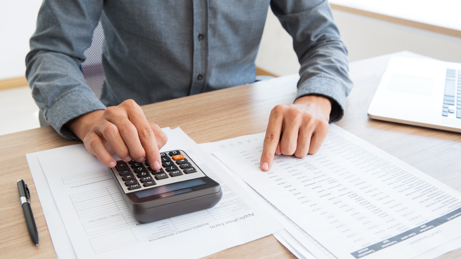 mano de hombre haciendo cuentas con una calculadora