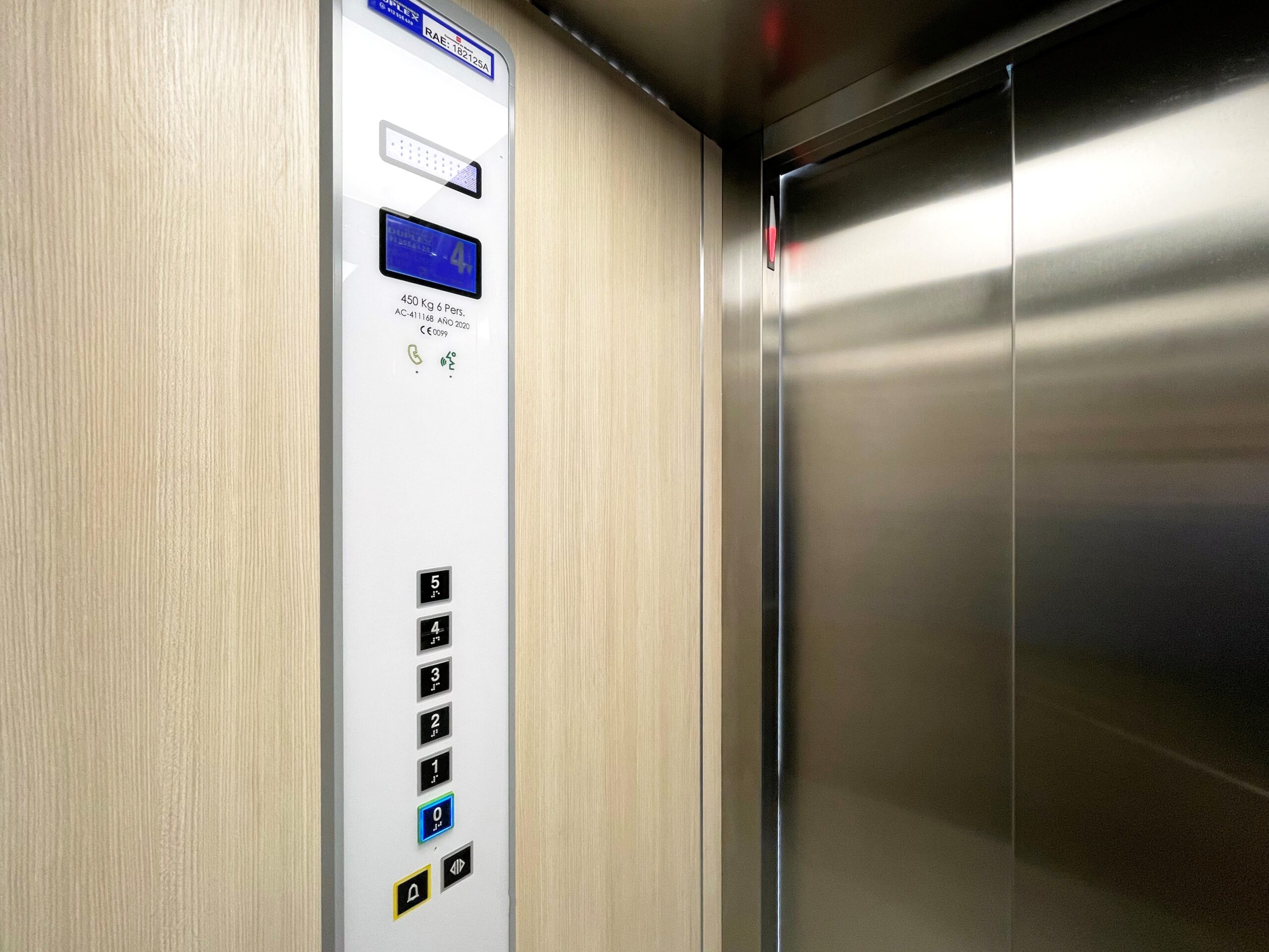 Ejemplo de placa con el número RAE, año de instalación, marcado CE, carga y capacidad del ascensor situada en la botonera de la cabina