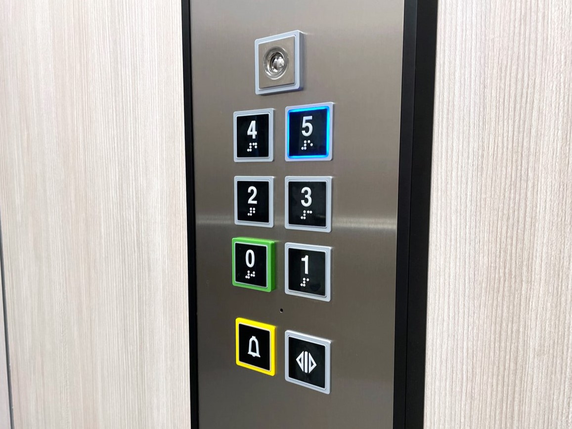 Primer plano de la botonera de un ascensor con botón de emergencia
