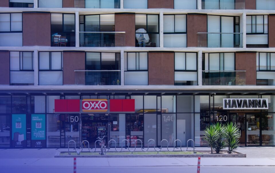 Vista de una calle con locales comerciales en planta baja dentro de un edificio residencial con ascensores